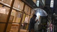 Seorang pria meninggalkan Koganeyu, yang merupakan sento atau pemandian umum di bangsal Sumida Tokyo, Jepang, Selasa, (13/8/2022). 