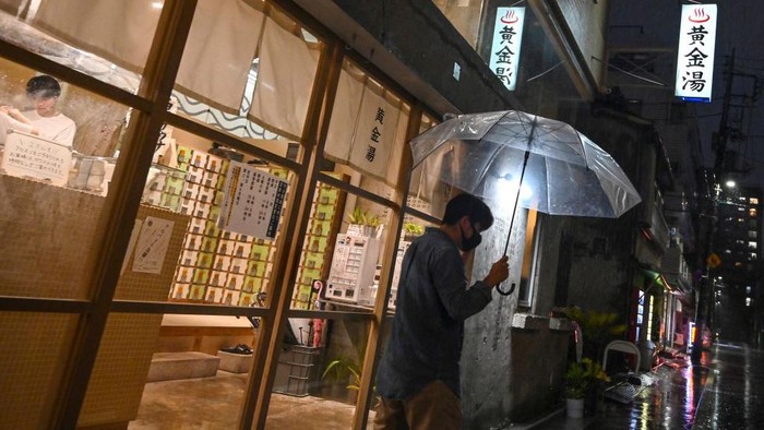 This photo taken on August 13, 2022 shows customers at the entrance to Koganeyu, which is a 