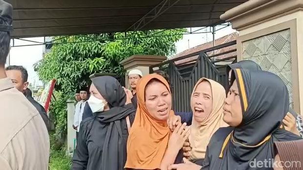 Tangisan keluarga saat ambulans yang membawa jasad Aipda Ahmad Karnain tiba di rumah duka. (Tommy Saputra/detikSumut)
