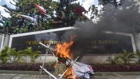 Sejumlah mahasiswa menaiki tembok kantor DPRD NTB dan memegang bendera saat berunjuk rasa di depan kantor DPRD NTB, Mataram, NTB, Senin (5/9/2022). (Ahmad Subaidi/Antara Foto)