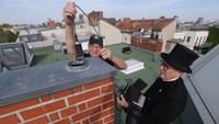 Norbert Skrobek menggunakan baju khas dan topi panjang mengecek cerobong asap di sebuah apartemen di Kota Berlin, Jerman, Senin (5/9/2022).  Skrobek mengatakan, dia menerima permintaan besar dari warga Berlin yang ingin menggunakan batu bara atau kayu untuk memanaskan apartemen mereka. Kayu dan batu bara dipilih karena gas alam harganya semakin meroket.