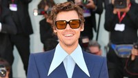 Yang unik dari busana Harry Styles adalah kemeja biru yang dia kenakan punya kerah tajam dan panjang hingga ke bagian dada. (Foto: WireImage/Dominique Charriau)
