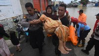 Seorang Ibu-ibu dievakuasi oleh personel TNI dan Polri. Banjir di Palu kali ini merupakan terparah dalam 10 tahun terakhir.