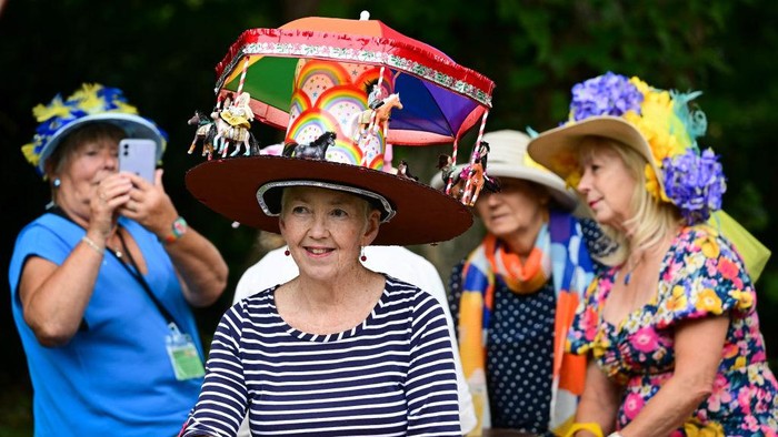Beragam Topi Unik Meriahkan Festival Topi di Inggris BRIDPORT, ENGLAND - SEPTEMBER 03: Participants gather for the traditional group hat photo at Bridport Hat Festival, on September 03, 2022 in Bridport, England. Bridport's quirky Hat Festival features hundreds of participants dressed in elegant, creative, technically ingenious and often bizarre creations. Along with various 'Best Hatted' competitions, there is 'Hat Hurling' and 'Best Hatted Dog' raising money for head-related charities. (Photo by Finnbarr Webster/Getty Images)