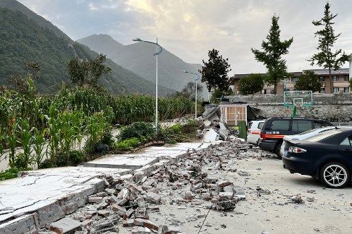 Firefighters gather near a damaged wall of a fire station after a 6.6-magnitude earthquake in Hailuogou in China's southwestern Sichuan province on September 5, 2022. (Photo by AFP) / China OUT