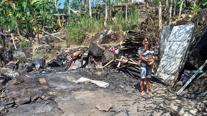 Kadek Suni bersama anaknya saat ditemui di rumahnya yang hangus terbakar di Banjar Dinas Tukad Tiis, Desa Seraya Timur