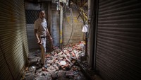 Seorang petugas mendatangi lokasi bangunan pasar yang hancur akibat kebakaran. (Sanchit Khanna/Getty Images)