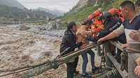 Para lansia diselamatkan melewati sungai dengan aliran air kencang. Gempa ini mengakibatkan 46 orang tewas dan 16 orang belum ditemukan.   