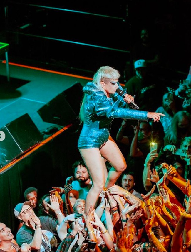 Tampil dengan rambut punk hingga makeup warna-warni menjadi ciri khasnya. Dia pun tak segan tampil topless, bahkan membawa penari latar striptis. Foto: dok. Instagram/@peachesnisker