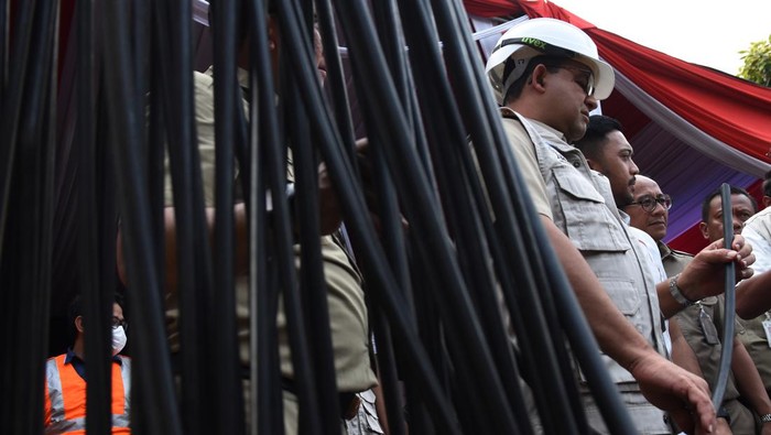 Petugas Bina Marga DKI Jakarta menurunkan kabel utilitas di Pasar Mampang Prapatan, Jakarta, Senin (5/9/2022). Dinas Bina Marga DKI Jakarta menurunkan 58 kabel utilitas dari 39 operator jaringan telekomunikasi di kawasan Mampang Prapatan yang menjuntai di udara untuk dipindahkan ke Sarana Jaringan Utilitas Terpadu (SJUT) di bawah tanah. ANTARA FOTO/Indrianto Eko Suwarso/rwa.