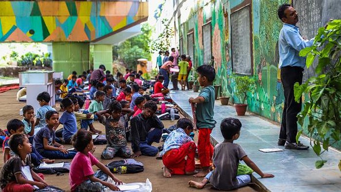 Semangat Guru di India Ajar Anak-anak di Kolong Jembatan NEW DELHI, INDIA - SEPTEMBER 05: Teacher Rajesh Kumar teaches Children at a makeshift school under a metro bridge on World Teachers' Day in New Delhi, India on September 05, 2022. The free school underneath the metro bridge is run by teacher Rajesh Kumar and Laxmi Chandra for children who come from the slums situated adjacent to the Yamuna river. (Photo by Amarjeet Kumar Singh/Anadolu Agency via Getty Images)