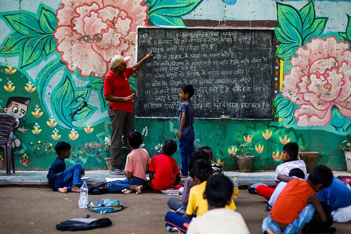 NEW DELHI, INDIA - SEPTEMBER 05: Laxmi Chandra Teacher teaches Children at a makeshift school under a metro bridge on World Teachers Day in New Delhi, India on September 05, 2022. The free school underneath the metro bridge is run by teacher Rajesh Kumar and Laxmi Chandra for children who come from the slums situated adjacent to the Yamuna river. (Photo by Amarjeet Kumar Singh/Anadolu Agency via Getty Images)