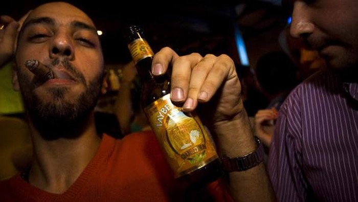 TOPSHOT - A bartender serves visitors on September 2, 2022, during the annual annual Oktoberfest beer festival in the village of Taybeh in the village of Taybeh, east of the occupied West Bank city of Ramallah, home of the Palestinian Taybeh brewery founded in 1994. - Ever since 2005, the Taybeh brewery has been brewing beer under challenging circumstances. Now the brewery is run by a woman, Madees Khoury, adding an extra layer of complication. Run as a two-day weekend event, Oktoberfest at Taybeh is as much about Palestinian identity as it is about drinking beer. (Photo by Abbas MOMANI / AFP) (Photo by ABBAS MOMANI/AFP via Getty Images)