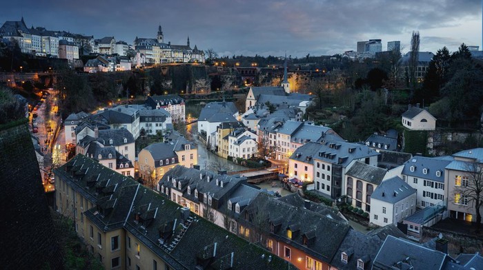 Luxembourg city skyline at night - Aerial view of The Grund with St Michaels Church on background - Luxembourg City, Luxembourg