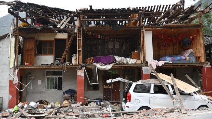 LUDING, CHINA - SEPTEMBER 06: People walk by damaged buildings in Moxi town on September 6, 2022 in Luding County, Garze Tibetan Autonomous Prefecture, Sichuan Province of China. A 6.8-magnitude earthquake jolted Luding county in Southwest Chinas Sichuan province on Monday, leaving at least 46 people dead and over 50 injured. (Photo by VCG/VCG via Getty Images)