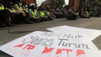 Anggota polisi duduk di depan pagar Gedung DPRD Kediri, Jawa Timur, Selasa (6/9/2022) untuk mengamankan jalannya massa mahasiswa dari Ikatan Mahasiswa Muhammadiyah (IMM) yang demo kenaikan harga BBM. Terlihat poster yang tergeletak di depan para polisi yang sedang duduk. (Prasetia Fauzani/Antara Foto)
