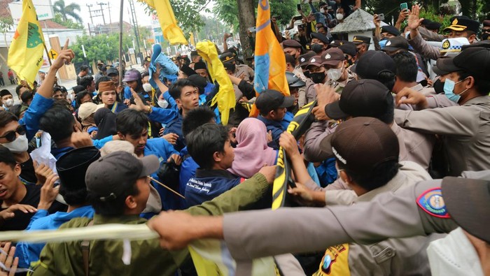 Demo BBM di Sejumlah Daerah Sejumlah polisi mengawal jalannya unjuk rasa mahasiswa yang tergabung dalam Pergerakan Mahasiswa Islam Indonesia (PMII) di depan Gedung DPRD Kabupaten Jombang, Jawa Timur, Selasa (6/9/2022). Unjuk rasa menolak kenaikan harga bahan bakar minyak (BBM) itu berlangsung ricuh, karena mahasiswa memaksa masuk ke gedung dewan untuk bertemu wakil rakyat. ANTARA FOTO/Syaiful Arif/wsj.