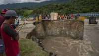 Warga menyaksikan jembatan yang putus akibat tergerus banjir di Desa Pakuli, Gumbasa, Sigi, Sulawesi Tengah, Selasa (6/9/2022).   