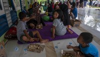 Sejumlah warga korban banjir menyantap bantuan nasi bungkus di teras Masjid Al-Anshar di Desa Pakuli Utara, Gumbasa, Sigi, Sulawesi Tengah, Selasa (6/9/2022).   
