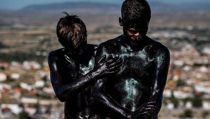 BAZA, SPAIN - SEPTEMBER 06: A man puts grease on another man before taking part in the festival of Cascamorras on September 06, 2022 in Baza, Spain. After two years of hiatus due to the pandemic, the traditional Cascamorras festival held in the cities of Baza and Guadix has returned. (Photo by Carlos Gil Andreu/Getty Images)