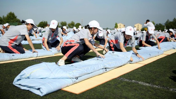 DONGYANG, CHINA - SEPTEMBER 06: Aerial view of freshmen competing in a quilt folding contest during a military training at Dongyang vocational education center school on September 6, 2022 in Dongyang, Jinhua City, Zhejiang Province of China. (Photo by VCG/VCG via Getty Images)