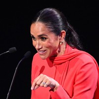Rambut panjang Meghan Markle dikuncir sederhana dengan gaya ponytail. Sepasang anting emas pun terlihat menghasi telinganya. (Foto: AFP via Getty Images/OLI SCARFF)