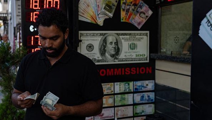 A customer holds Turkish lira banknotes outside a currency changer on a street in Istanbul on September 6, 2022, as Turkey's economy is suffering its biggest economic crisis in decades ahead of one of the toughest elections of President Recep Tayyip Erdogan's rule. - Turkey's official inflation rate barely changed on September 5, in a sign that a year-long crisis that has seen prices soar by 80 percent may finally be starting to ease. The TUIK state statistics agency said that consumer prices rose by 80.2 percent in August from a year earlier. The crisis has seen the ruling party's approval ratings drop to historic lows heading into the next general election due by June 2023. (Photo by Yasin AKGUL / AFP) (Photo by YASIN AKGUL/AFP via Getty Images)