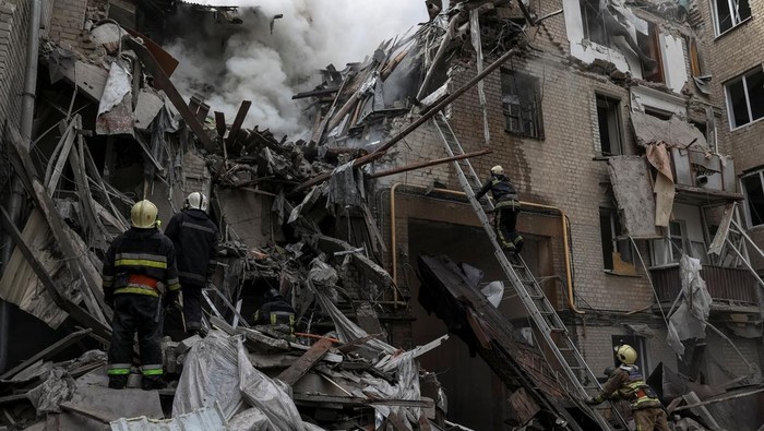 Porak-poranda Apartemen di Ukraina Akibat Dihantam Rudal Rusia Firefighters work at the site of a residential building hit by a Russian military strike, amid Russia's attack on Ukraine, in Kharkiv, Ukraine September 6, 2022. REUTERS/Sofiia Gatilova