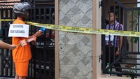 Aipda Rudy Suryanto memeragakan adegan penembakan ke Aipda Ahmad Karnain. Kanit Provos Polsek Pengubuan itu menembak rekannya dari luar pagar rumah Aipda Ahmad Karnain.  (Foto: Istimewa)