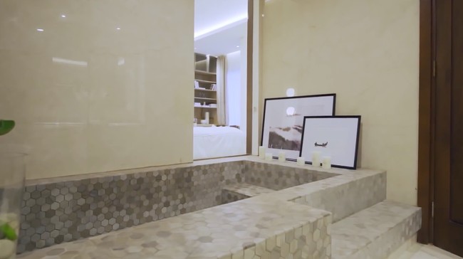 Kenapa harus beli, kalau bisa buat? Setidaknya itu yang Roger dan Cut pikirkan ketika ingin menghadirkan bathtub di kamar mandi utama. Alih-alih membeli, mereka membuat bathtub yang seperti kolam kecil dengan material batuan heksagonal yang modern. (Foto: YouTube/Rakta Studio)