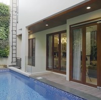 Halaman belakang difungsikan semaksimal mungkin untuk kolam renang. Meski tidak ada ruang terbatas untuk taman, mereka memanfaatkan dinding sebagai taman vertikal. (Foto: YouTube/Rakta Studio)