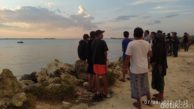 Warga Bangkalan menyaksikan proses evakuasi pesawat TNI AL yang jatuh dari tepi pantai