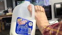 Selain gelas, botol, kini ada netizen yang memegang botol susu berukuran besar dengan ibu jari kakinya. Kalau cara pegangnya seperti ini, bisa-bisa kakinya pegal. Foto: Twitter