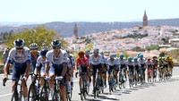 Remco Evenepoel mengenakan jersey warna merah, dikawal satu tim Quick-Step - Alpha Vinyl pada etape ke-17, Vuelta a Espana 2022. Ia memuncaki klasemen sementara pada grand tour ini. Ia semakin tak terkejar usai juara bertahan Primoz Roglic angkat kopor karena kecelakaan. (Justin Setterfield/Getty Images)