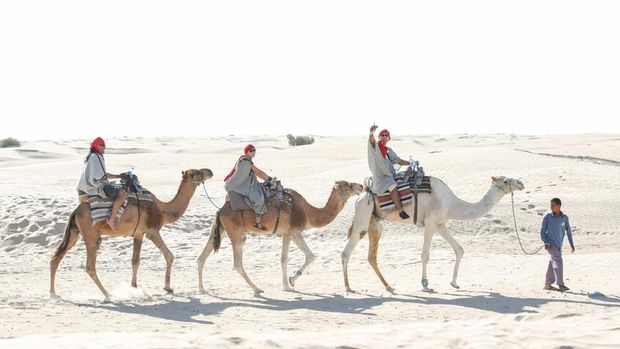 Douz, Kebili, Tunisia - September 17, 2012 : Bedouins leading tourists on camels at short tourist tour around the beginning of Sahara desert in Douz, Tunisia.