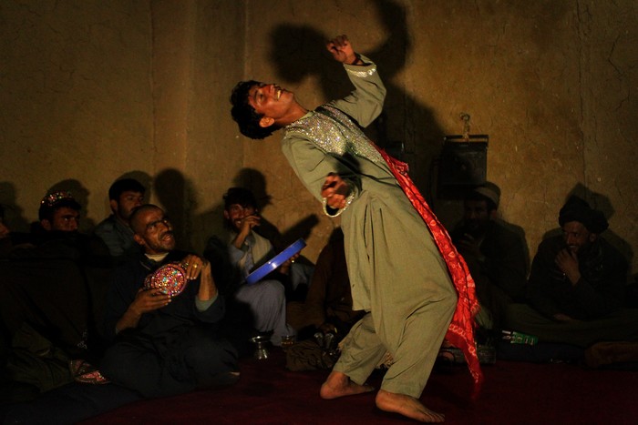 Bacha Bazi URUZGAN PROVINCE, AFGHANISTAN - JANUARY: Afghan men perform the Bazi dance to a group of policemen in Charchino in Uruzgan province, Afghanistan, January 27, 2013. The performance is based upon the Bacha Boy dances that were common during the Taliban reign when Bacha Boys were prostituted to wealthy men and made to perform. (Photo by Kate Geraghty/The Sydney Morning Herald/Fairfax Media via Getty Images via Getty Images).