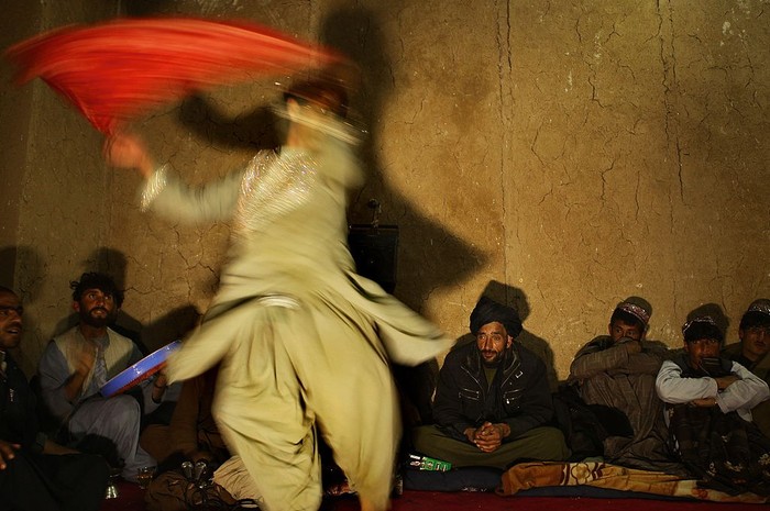 Pria Afghanistan melakukan tarian Bazi kepada sekelompok polisi di Charchino di provinsi Uruzgan, Afghanistan, 27 Januari 2013. Tarian ini lumrah dilakukan di masa itu.