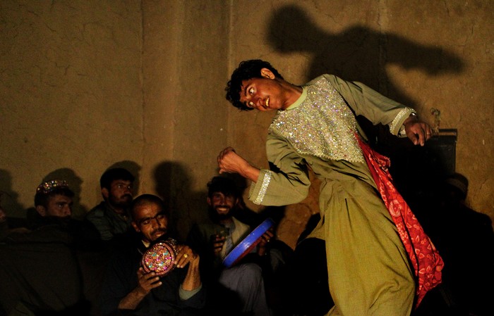 URUZGAN PROVINCE, AFGHANISTAN - JANUARY:   Afghan men perform the Bazi dance to a group of policemen in Charchino in Uruzgan province, Afghanistan, January 27, 2013. The performance is based upon the Bacha Boy dances that were common during the Taliban reign when Bacha Boys were prostituted to wealthy men and made to perform. (Photo by Kate Geraghty/The Sydney Morning Herald/Fairfax Media via Getty Images via Getty Images).