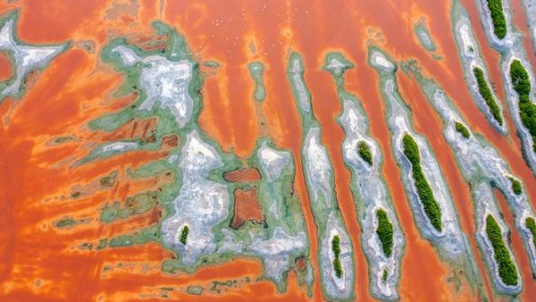 Pantulan cahaya matahari berpendar di permukaan danau. Danau Garam Yuncheng di Tiongkok Utara itu memiliki kandungan natrium sulfat terbesar ketiga di dunia. Ia berfungsi sebagai salah satu sumber garam paling penting di Tiongkok.  
