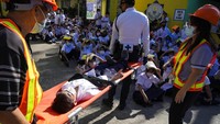 Seorang siswa digotong dengan tandu oleh tim SAR sebagai simulasi untuk menolong korban yang terkena gempa.