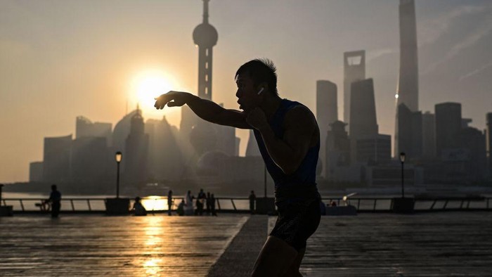 Menikmati Indahnya Matahari Terbit di Sungai Huangpu, Shanghai A man practices shadow boxing on the Bund promenade along the Huangpu River during sunrise in Shanghai on September 7, 2022. (Photo by HECTOR RETAMAL / AFP) (Photo by HECTOR RETAMAL/AFP via Getty Images)