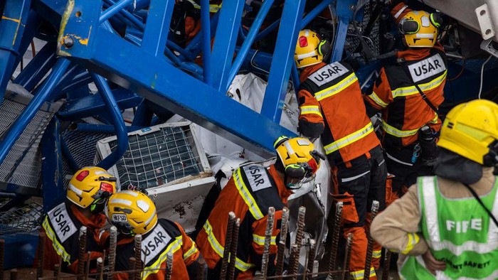 Ngeri, Crane Roboh di Hong Kong Tewaskan Dua Orang Pekerja Members of the Urban Search And Rescue (USAR) team (L) work on a collapsed crane in Hong Kong on September 7, 2022, where two people died and six were injured at a construction site. (Photo by ISAAC LAWRENCE / AFP) (Photo by ISAAC LAWRENCE/AFP via Getty Images)