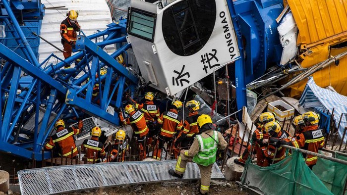 Members of the Urban Search And Rescue (USAR) team (L) work on a collapsed crane in Hong Kong on September 7, 2022, where two people died and six were injured at a construction site. (Photo by ISAAC LAWRENCE / AFP) (Photo by ISAAC LAWRENCE/AFP via Getty Images)