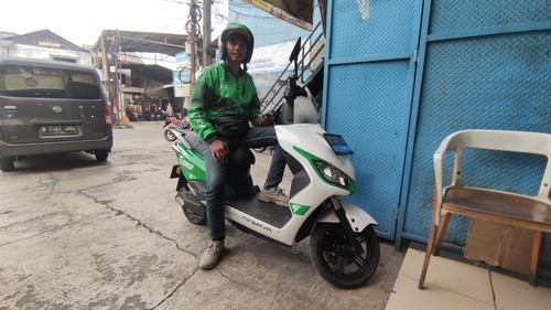 Ojek online mengendarai motor listrik