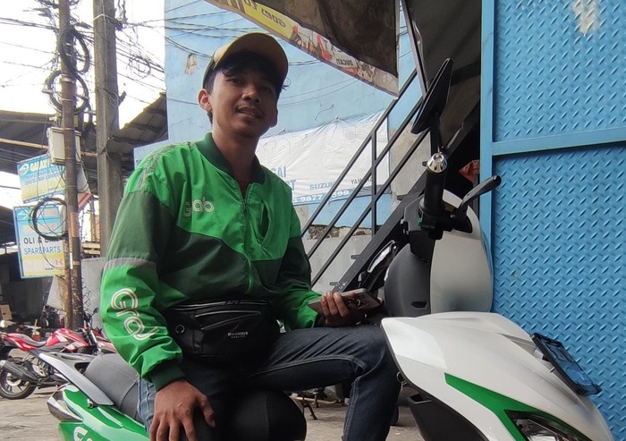 Ojek online mengendarai motor listrik