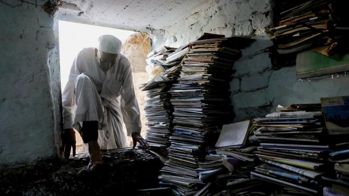 Abdallaa Abu Dawh, 82, a former teacher at Egypt's Al-Azhar university who now works as an imam, reads in a library at his basement home which contains some 15,000 books collected in the course of his life, in the hope of making an impact by offering young men and women in his village in the Nile Delta books to read for free in Dakahlia governorate, north of Cairo, Egypt August 26, 2022. REUTERS/Mohamed Abd El Ghany      TPX IMAGES OF THE DAY