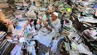 Kakek Abdallaa membaca di tengah tumpukan buku miliknya. Dia menawarkan secara gratis bagi warga desa yang ingin membaca di perpustakaannya.