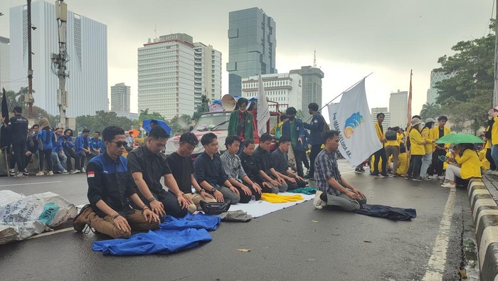 Sejumlah mahasiswa menggelar demo menolak kenaikan harga BBM di kawasan Patung Kuda, Jakarta. Sejumlah massa sempat menggelar salat di tengah guyuran hujan. (Rizky AM/detikcom)