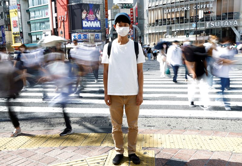 Shoji Morimoto who charges 10,000 yen ($71.30) per booking to accompany clients and simply exist as a companion, poses at Shibuya crossing in Tokyo, Japan August 31, 2022. REUTERS/Kim Kyung-Hoon REFILE - CORRECTING RATE