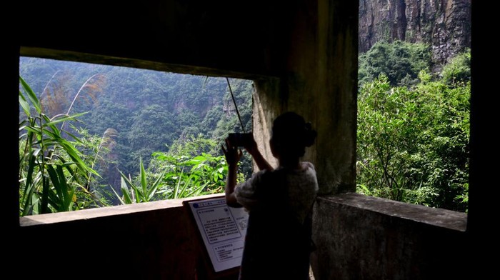 Taman Nasional Nanling Di Guangdong RUYUAN, CHINA - SEPTEMBER 07: A woman takes photos of a waterfall at the Ruyuan grand canyon on September 7, 2022 in Ruyuan County, Shaoguan City, Guangdong Province of China. Covering more than 3,600 hectares in southwest of Ruyuan county, the canyon features meadows, cliffs and waterfalls. Located at the southern foot of the middle range of Nanling Mountains and the northern part of Guangdong Province, Ruyang is regarded as an important natural ecological barrier of the Guangdong-Hong Kong-Macao Greater Bay Area. (Photo by Chen Jimin/China News Service via Getty Images)